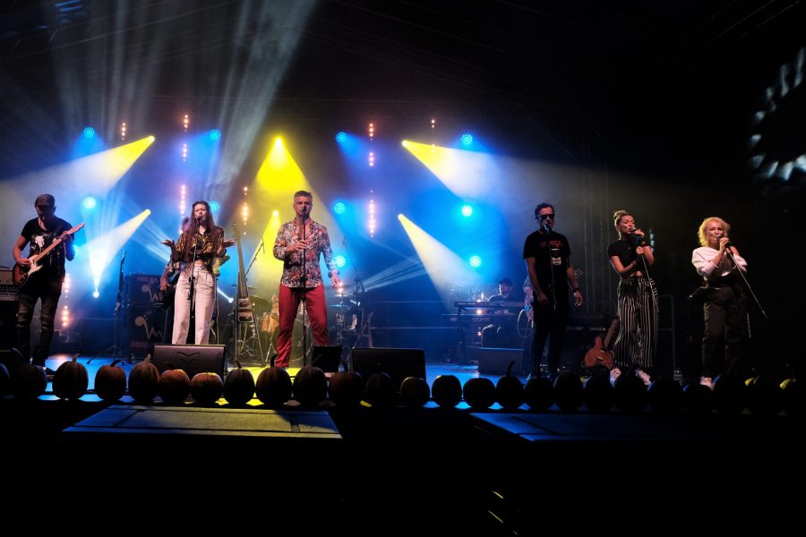 Zdjęcie zbiorowe ukazujące cały zespół na scenie