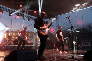 Koncert Budki Suflera na pierwszym planie gitarzysta Piotr Bogutyn